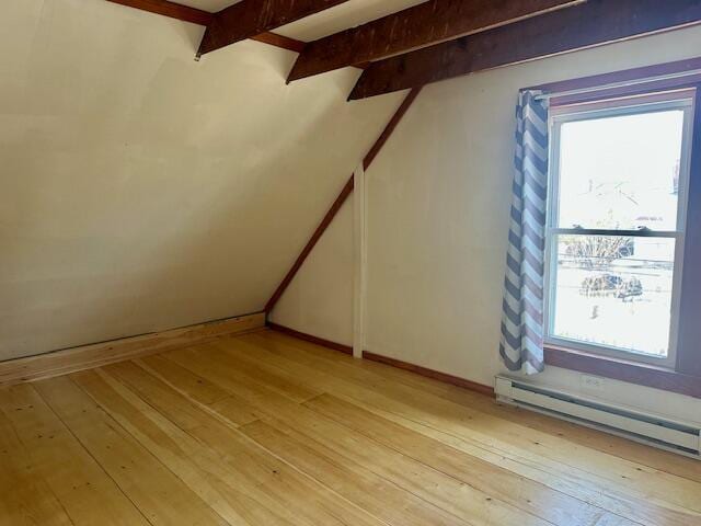 bonus room with a baseboard radiator, beam ceiling, baseboards, and light wood finished floors