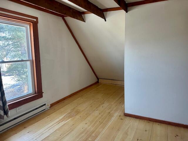 bonus room featuring a baseboard radiator, baseboards, beamed ceiling, and light wood-style flooring