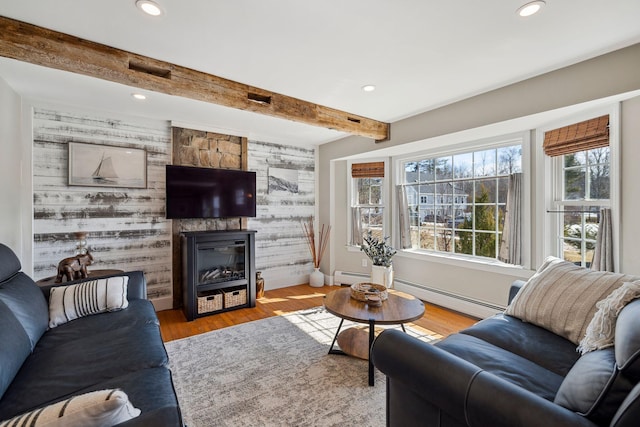 living room with a baseboard radiator, beam ceiling, a fireplace, recessed lighting, and light wood-style floors