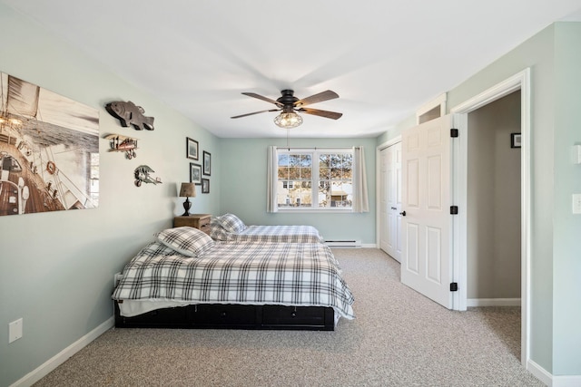 carpeted bedroom with a baseboard radiator, baseboards, a closet, and a ceiling fan