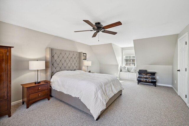 bedroom featuring baseboards, light colored carpet, lofted ceiling, and a ceiling fan