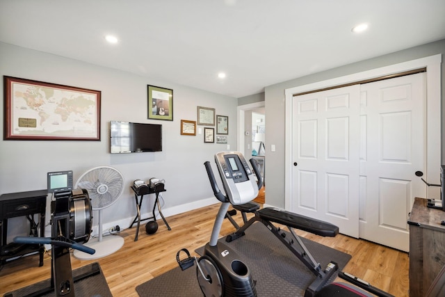 workout area featuring recessed lighting, light wood-style flooring, and baseboards