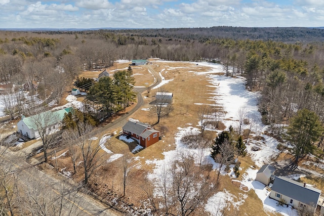 snowy aerial view featuring a forest view