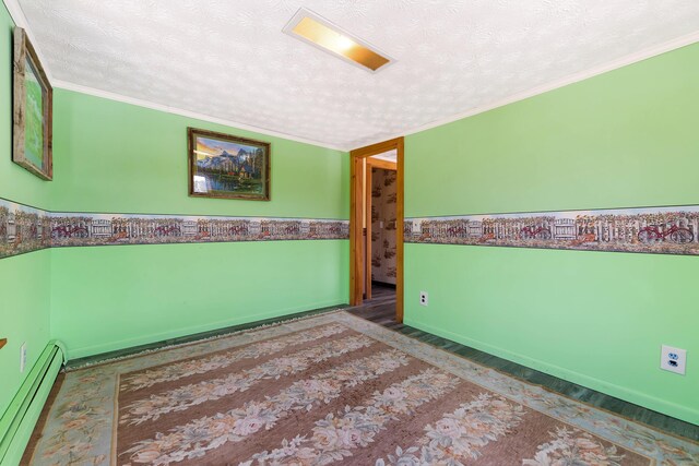 spare room with a baseboard radiator, a textured ceiling, wood finished floors, and crown molding