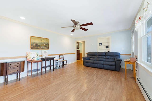 living room featuring a baseboard heating unit, ceiling fan, baseboards, light wood-type flooring, and ornamental molding