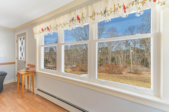 interior details with a baseboard heating unit, baseboards, wood finished floors, and ornamental molding