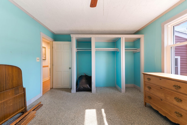 carpeted bedroom with a closet, baseboards, and a ceiling fan