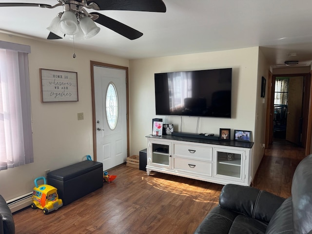 living room with dark wood-type flooring, baseboard heating, and ceiling fan