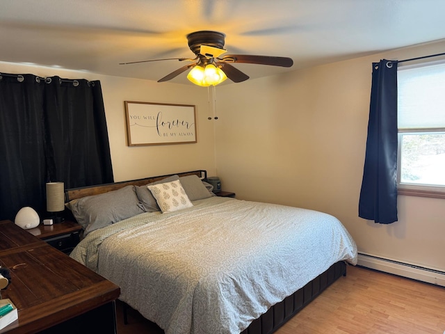 bedroom featuring baseboard heating, light wood-style flooring, and a ceiling fan