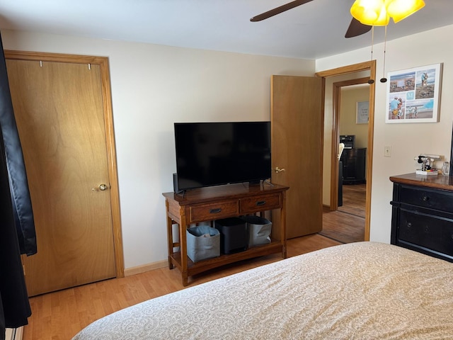 bedroom featuring a ceiling fan, wood finished floors, and baseboards