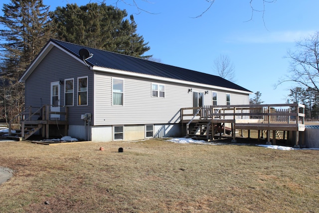 rear view of property with metal roof, a yard, and stairs