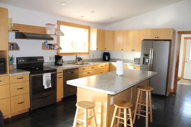 kitchen featuring light brown cabinetry, appliances with stainless steel finishes, wall chimney exhaust hood, and a kitchen bar