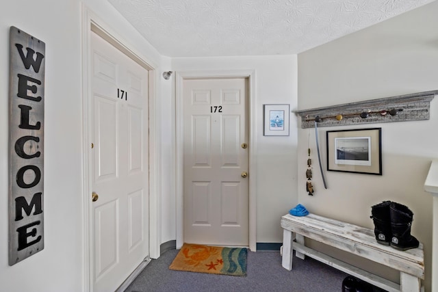 carpeted entrance foyer featuring a textured ceiling