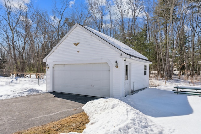 snow covered garage with a garage