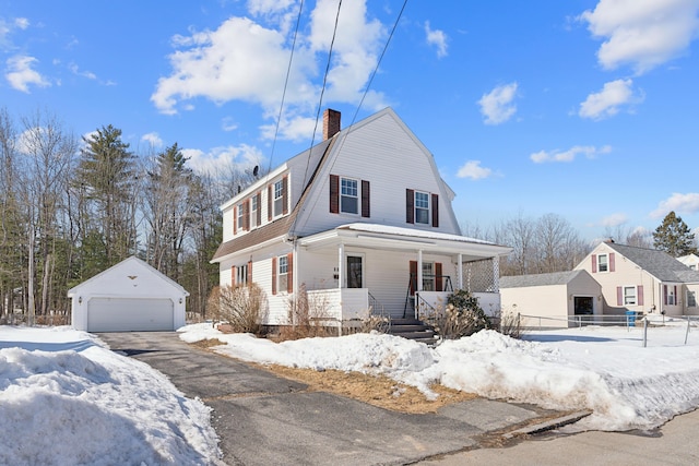 dutch colonial featuring a gambrel roof, covered porch, a chimney, a garage, and an outbuilding