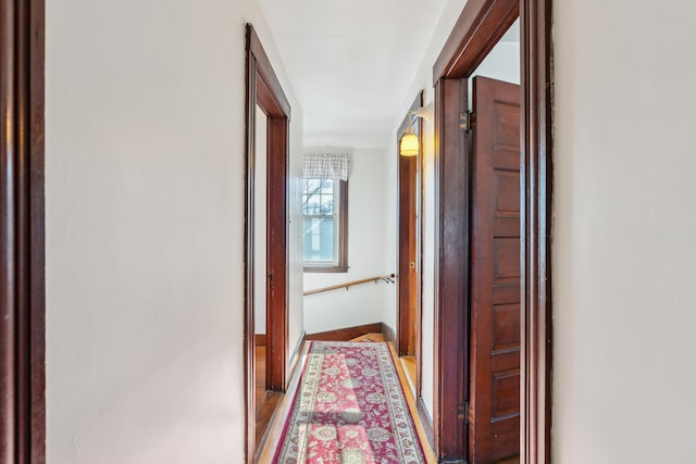 hall featuring baseboards and light wood finished floors