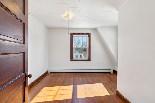 additional living space featuring baseboard heating, baseboards, and hardwood / wood-style floors