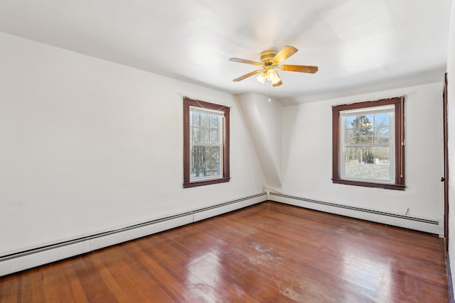 empty room with hardwood / wood-style floors, a ceiling fan, and baseboard heating