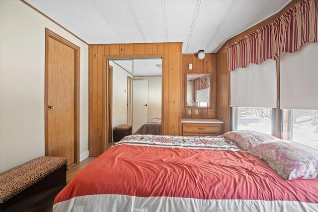 bedroom with wood finished floors and wood walls