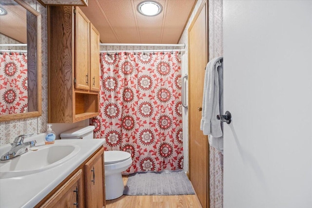 full bathroom with curtained shower, toilet, vanity, and wood finished floors