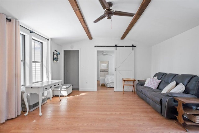 living room with a barn door, lofted ceiling with beams, and light wood-style floors