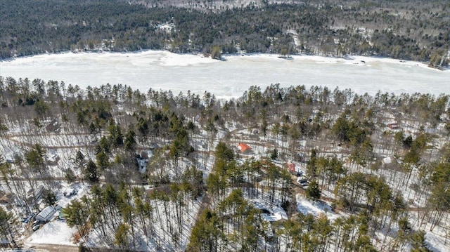 snowy aerial view featuring a wooded view