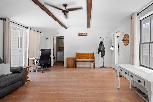 office space with baseboards, lofted ceiling with beams, light wood-style floors, washer / clothes dryer, and a ceiling fan