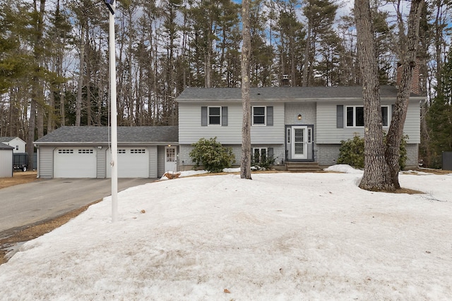 raised ranch with entry steps, an attached garage, and driveway