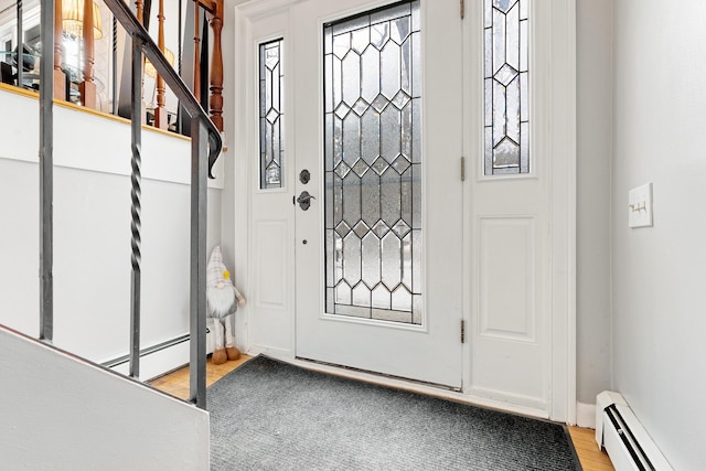 foyer entrance with light wood-type flooring and a baseboard radiator