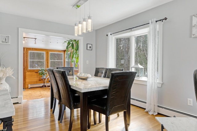 dining area with a baseboard heating unit, light wood-style floors, and a baseboard radiator