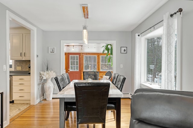 dining space featuring light wood-style flooring and baseboard heating