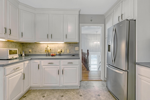 kitchen featuring tasteful backsplash, a toaster, white cabinetry, and stainless steel fridge with ice dispenser