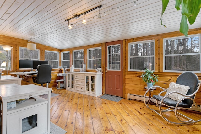 home office with hardwood / wood-style floors, a wealth of natural light, and wood walls