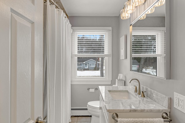 bathroom featuring a wealth of natural light, toilet, and baseboard heating