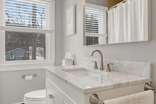 full bath with plenty of natural light, toilet, and vanity