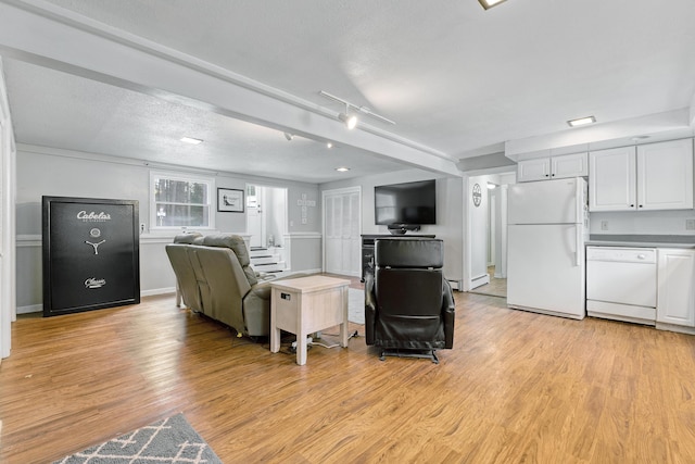 living area featuring a baseboard heating unit, light wood-style flooring, baseboards, and a textured ceiling