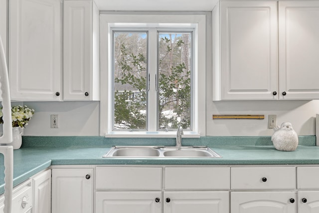 kitchen featuring a sink, plenty of natural light, and white cabinetry