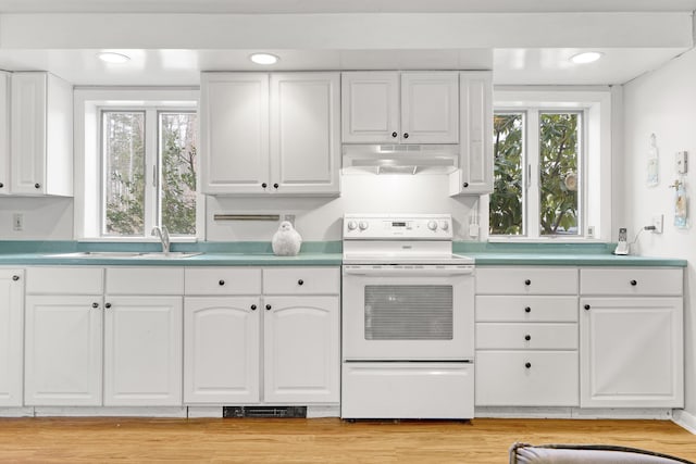 kitchen featuring under cabinet range hood, white cabinets, white electric stove, and a healthy amount of sunlight