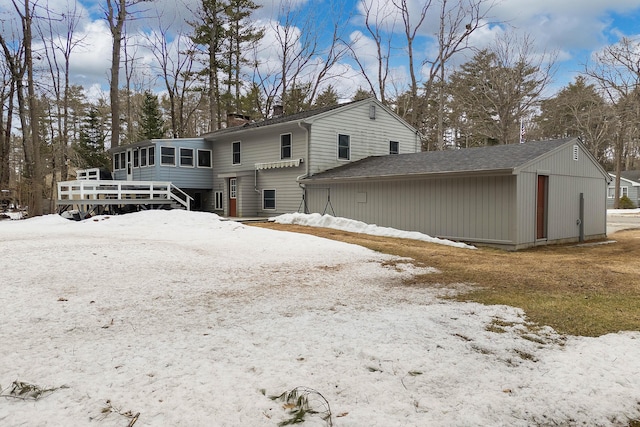 snow covered property with a chimney and a sunroom