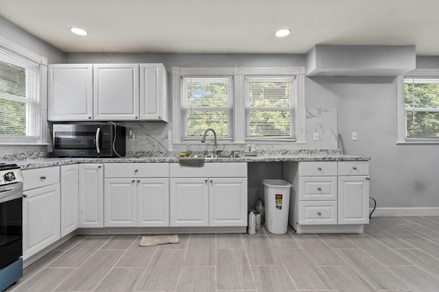 kitchen with a sink, decorative backsplash, white cabinets, and stainless steel appliances