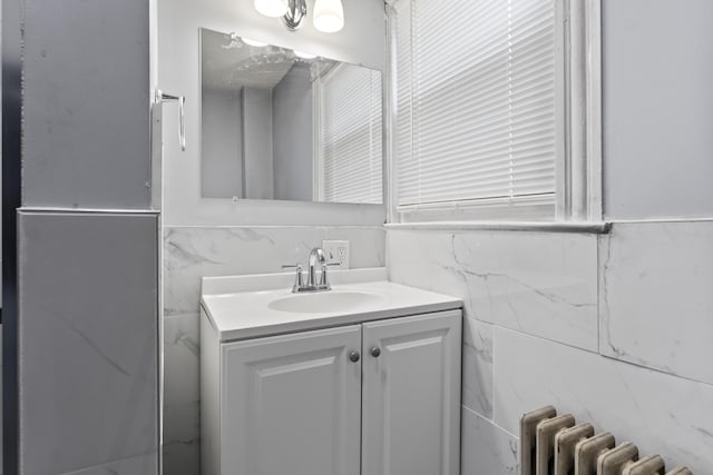 bathroom with vanity, tile walls, and radiator heating unit