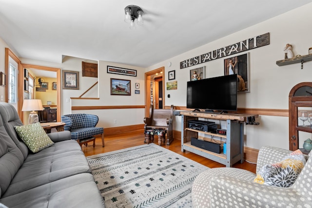 living area with baseboards and wood finished floors