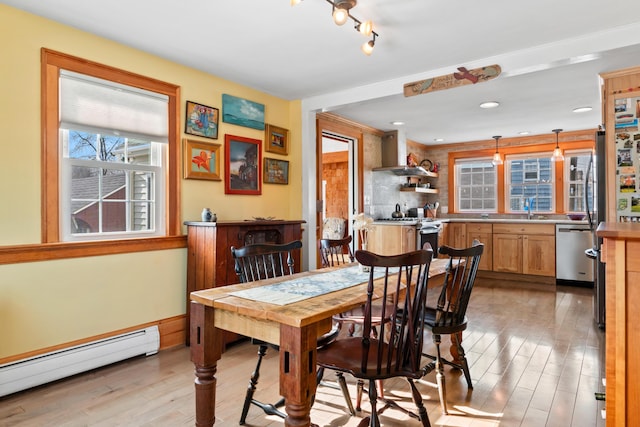 dining area featuring a baseboard radiator and light wood-style floors