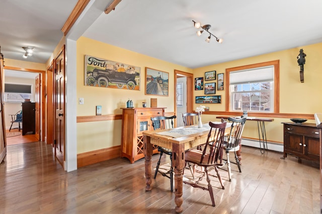 dining room with light wood-style floors, baseboards, and a baseboard radiator