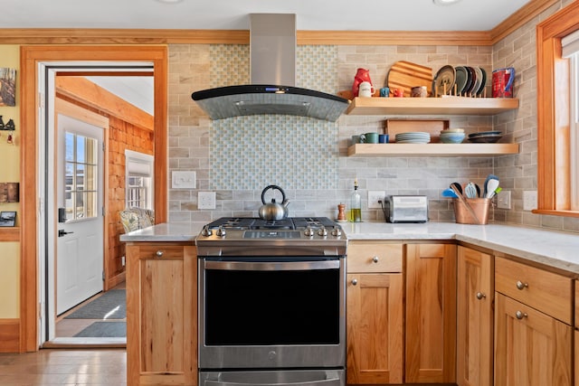 kitchen featuring stainless steel gas range oven, plenty of natural light, backsplash, and wall chimney exhaust hood