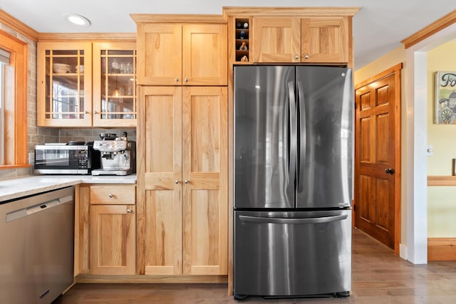 kitchen featuring wood finished floors, recessed lighting, decorative backsplash, glass insert cabinets, and appliances with stainless steel finishes