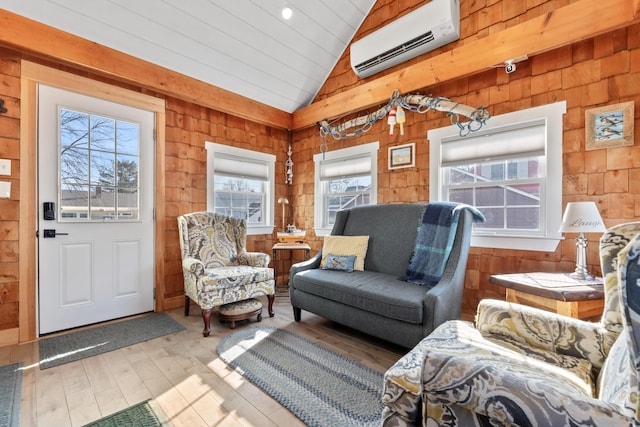 living room with wooden walls, wood finished floors, a wall mounted AC, and vaulted ceiling