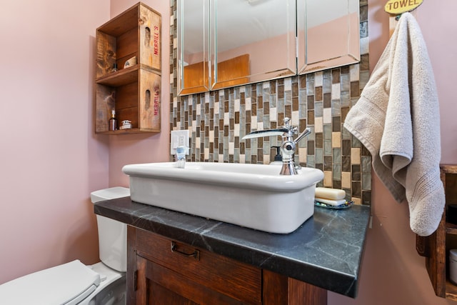 half bath featuring tasteful backsplash, vanity, and toilet