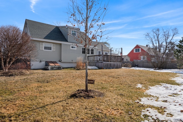 back of house with fence, a deck, a lawn, and a shingled roof