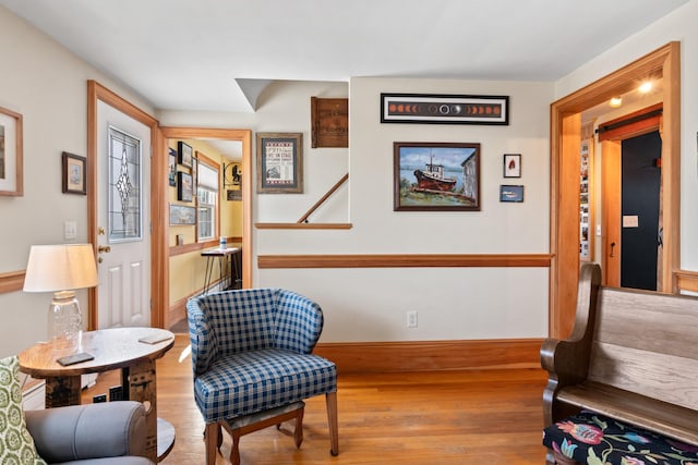 sitting room with baseboards and wood finished floors